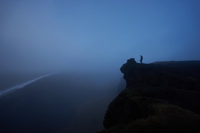 人站的岩石悬崖雾覆盖着
